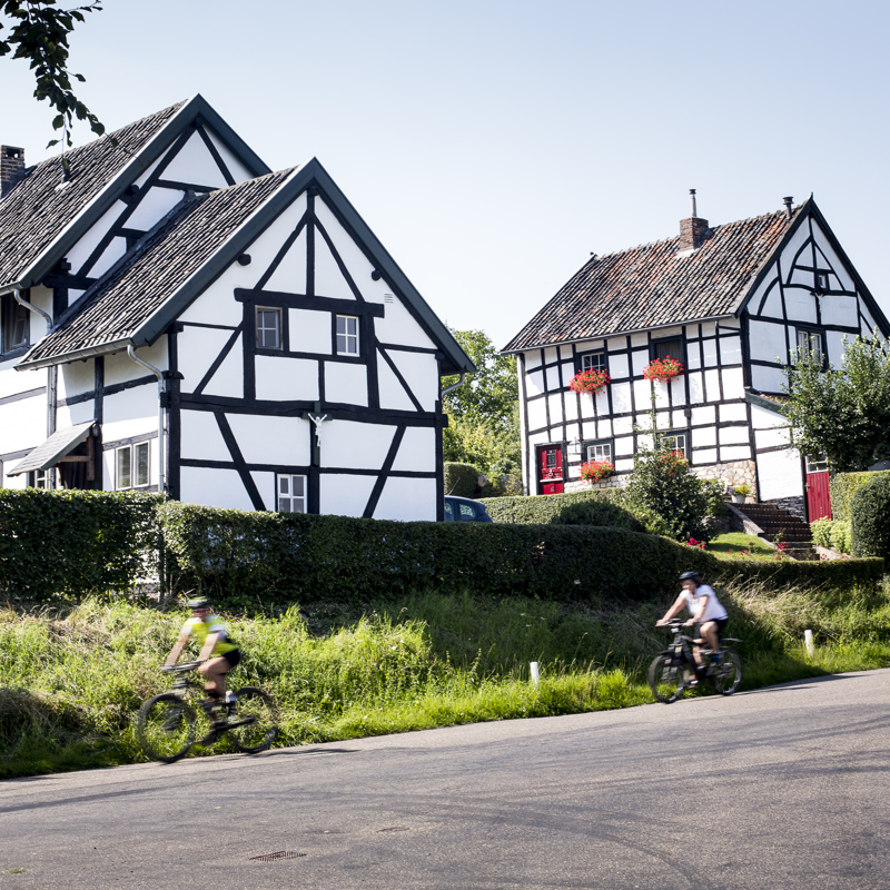 Vakwerkhuizen met voorbijrijdende fietsers