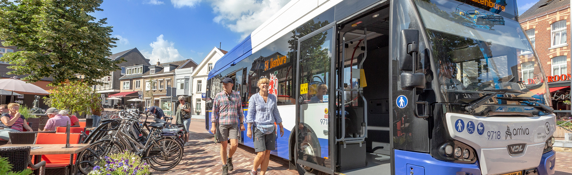 Opstappende mensen bij een bus in Gulpen markt